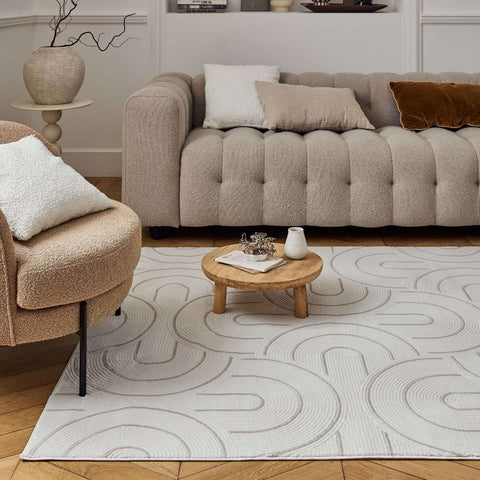 Beige tufted sofa with plush fabric and button detailing paired with carmel cream beige geometric rug 6070