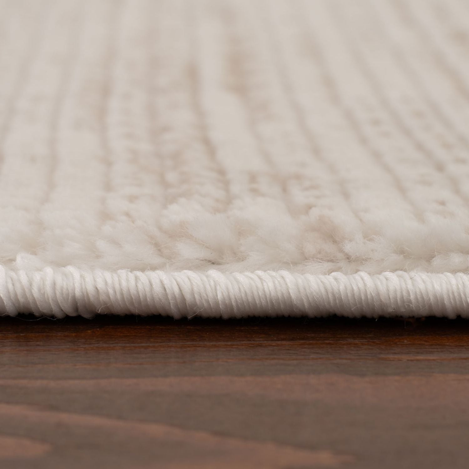 Cream beige striped rug with plush ribbed texture and white fringe perfect for cozy living spaces