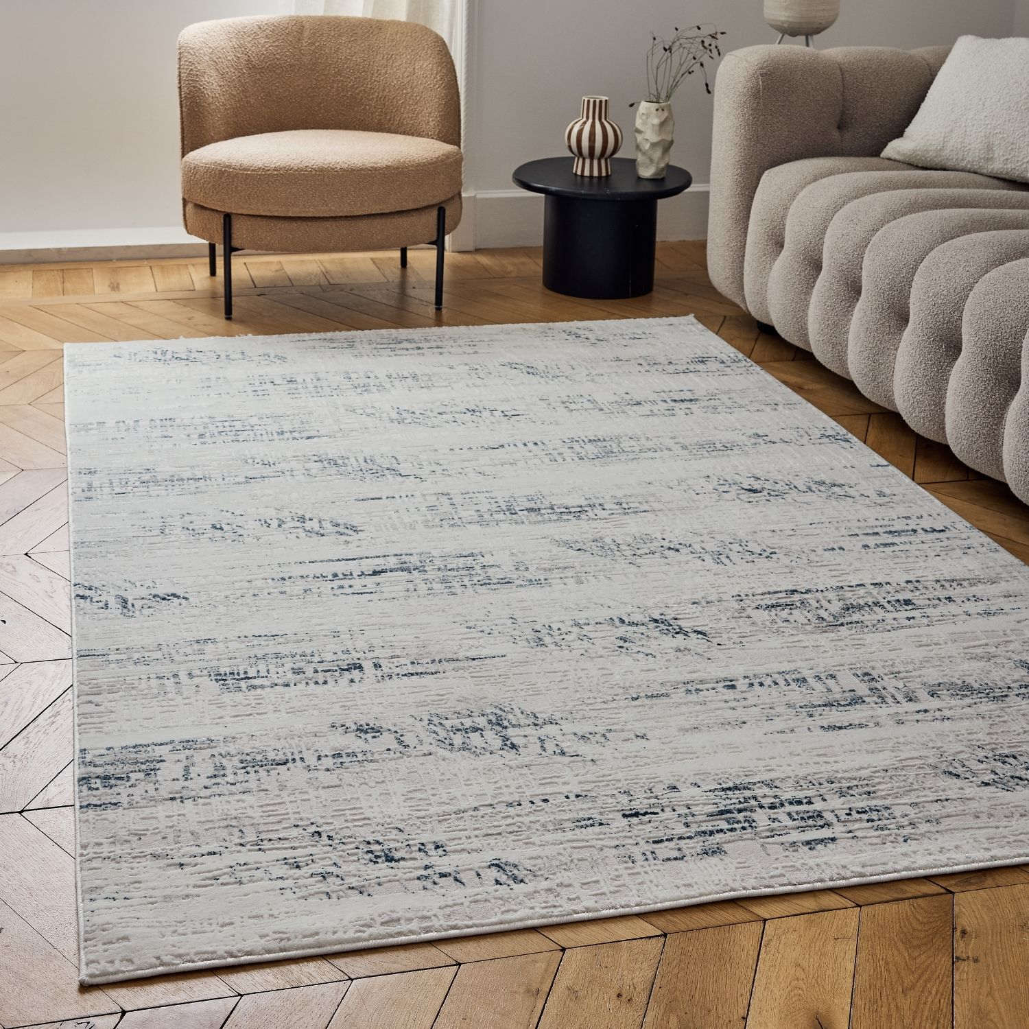A modern rectangular abstract rug in cream and blue with a textured pattern perfect for any living space
