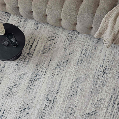 Carmel cream-blue abstract rug with textured neutral surface and black gray brushstroke designs on light beige background