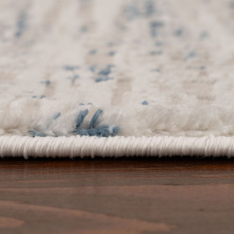 A plush carmel cream-blue abstract rug with subtle blue speckles and a tightly woven border perfect for any room