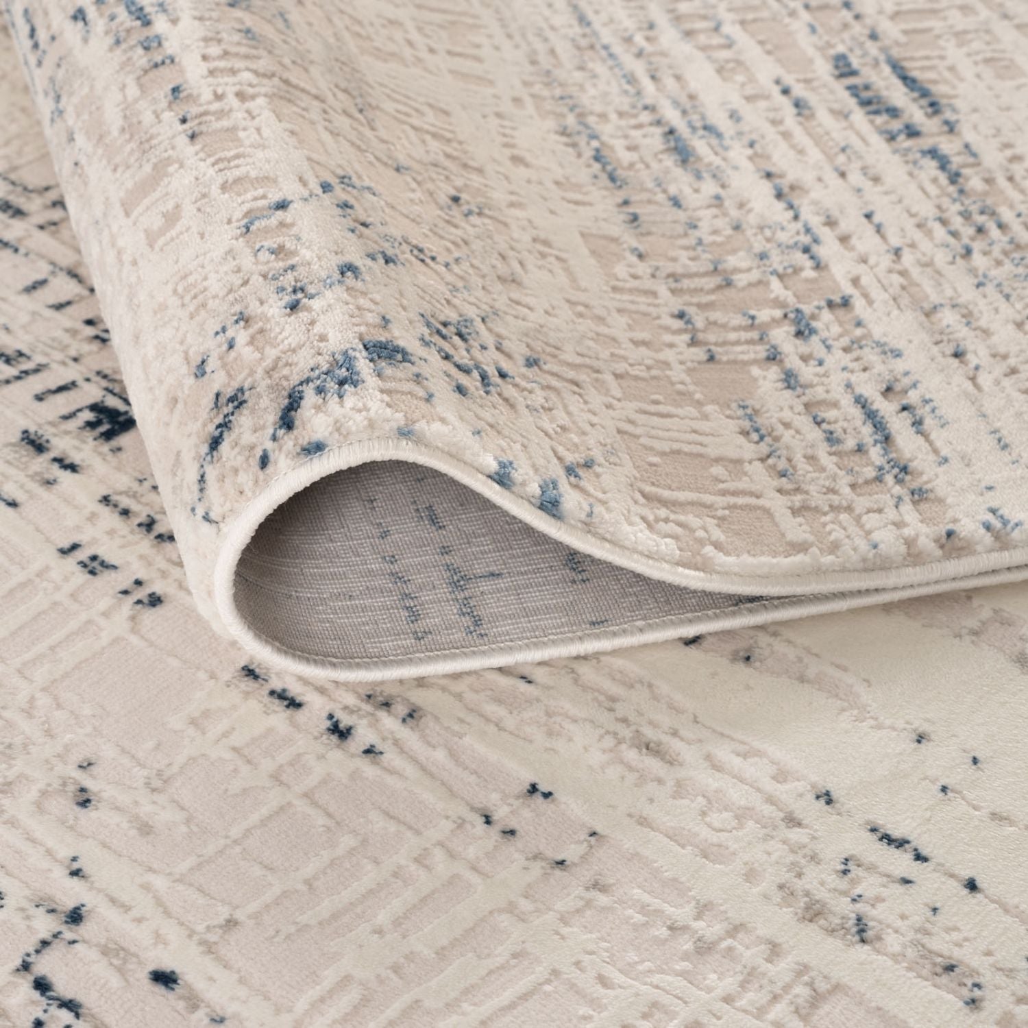A cream base abstract rug with blue abstract patterns and a soft pile finish perfect for cozy spaces