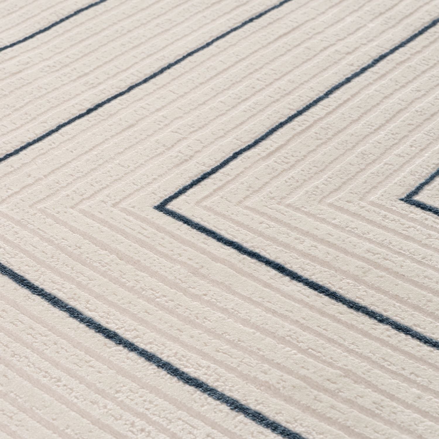 Cream-colored geometric rug with textured surface and bold navy blue chevron stripes for stylish decor