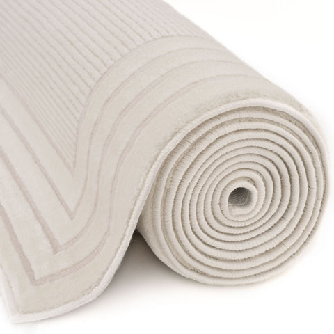 A soft off-white carmel cream bordered rug with ribbed texture and subtle geometric pattern perfect as a bath mat
