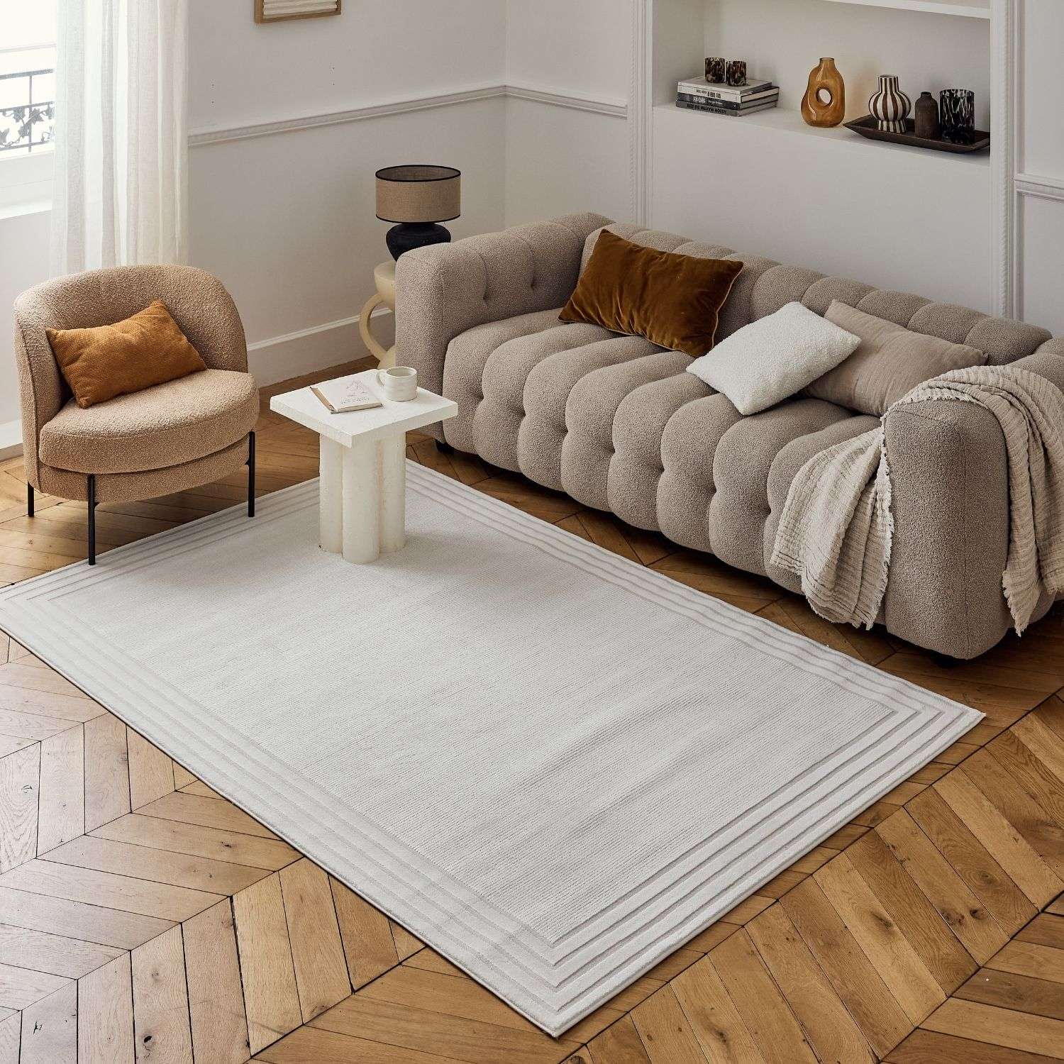 A soft off-white carmel cream bordered rug with a textured weave and subtle horizontal ribbed border