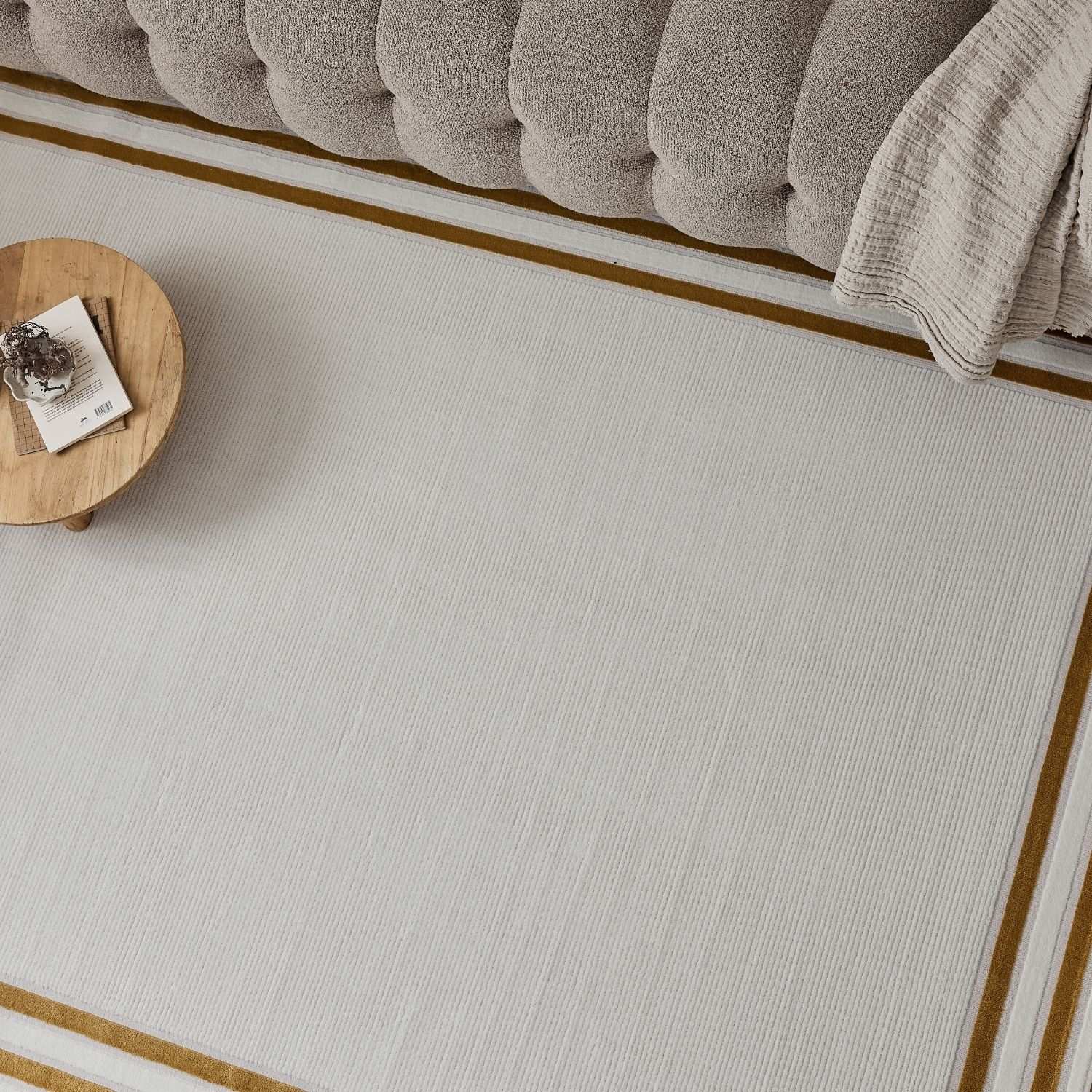 Beige rectangular bordered rug with subtle vertical ribbing and contrasting gold border for stylish spaces