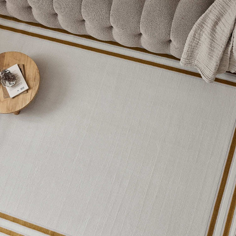 Beige rectangular bordered rug with subtle vertical ribbing and contrasting gold border for stylish spaces