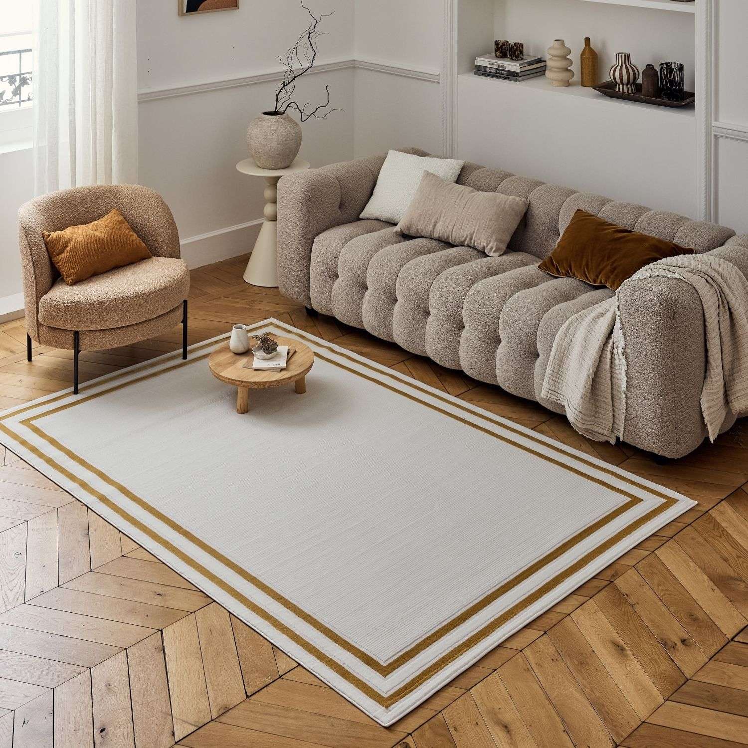 Beige rectangular bordered rug with textured surface and two parallel gold brown stripes carmel cream gold bordered rug
