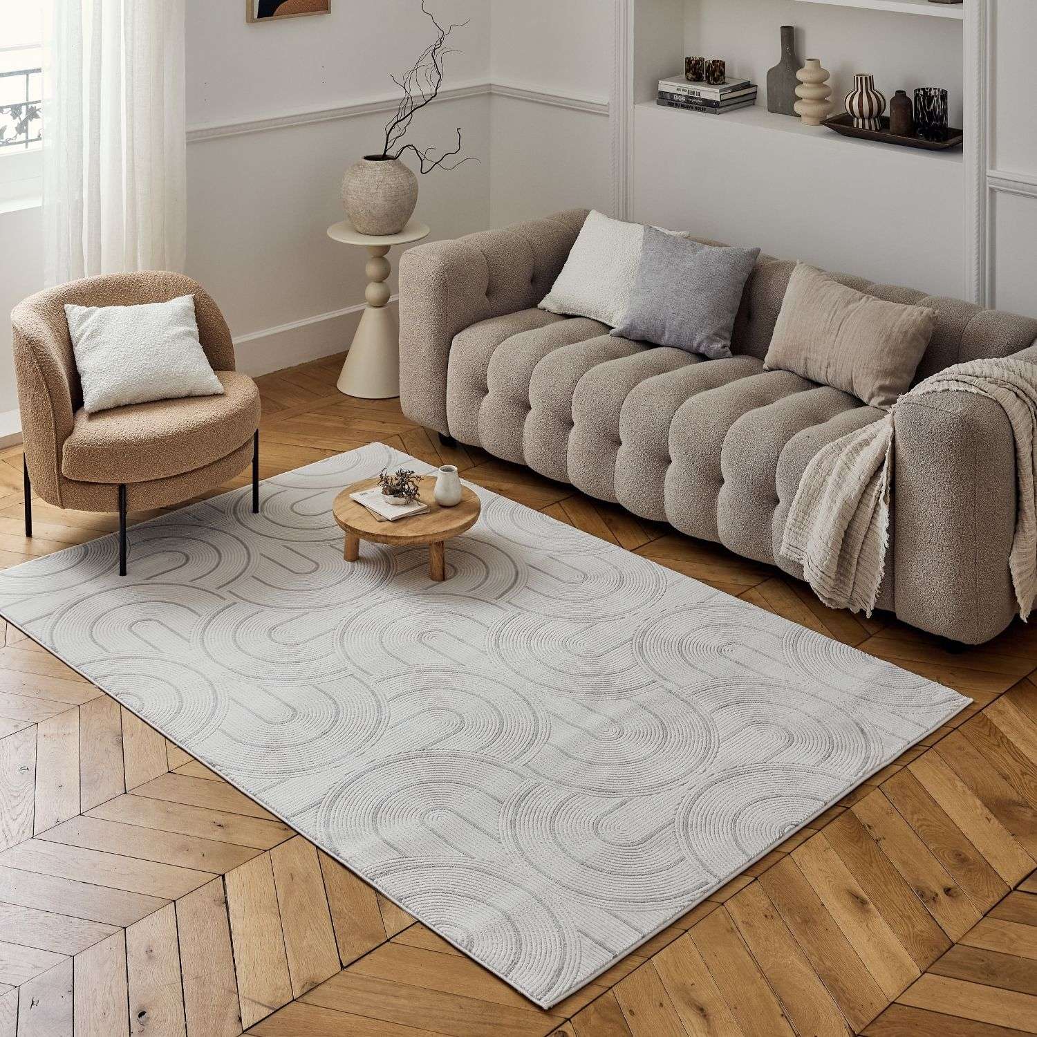 Light gray carmel cream-grey geometric rug with subtle wave pattern on wooden floor in cozy living room