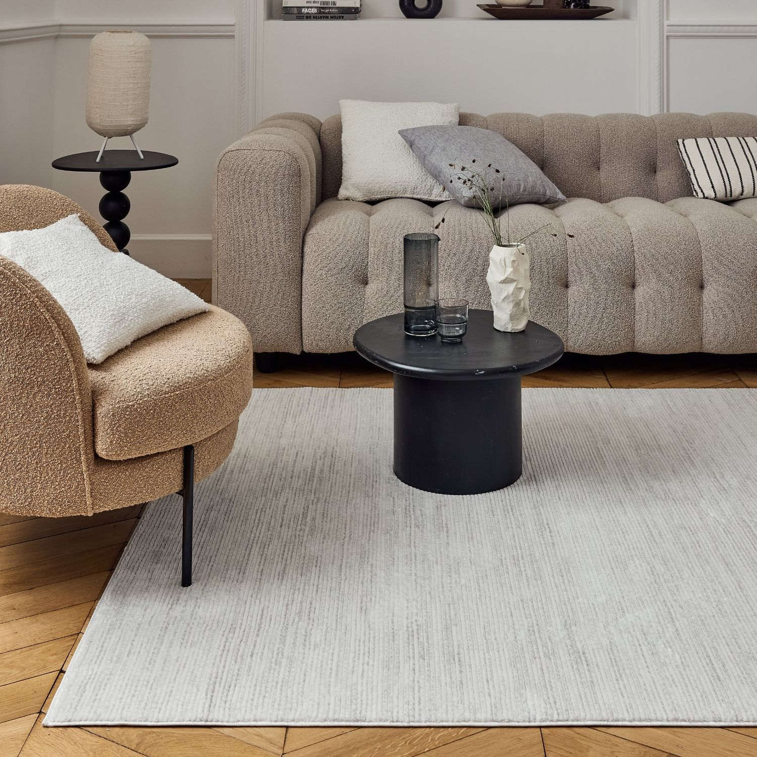 White textured ceramic vase with geometric ridged design displayed on a carmel cream grey striped rug