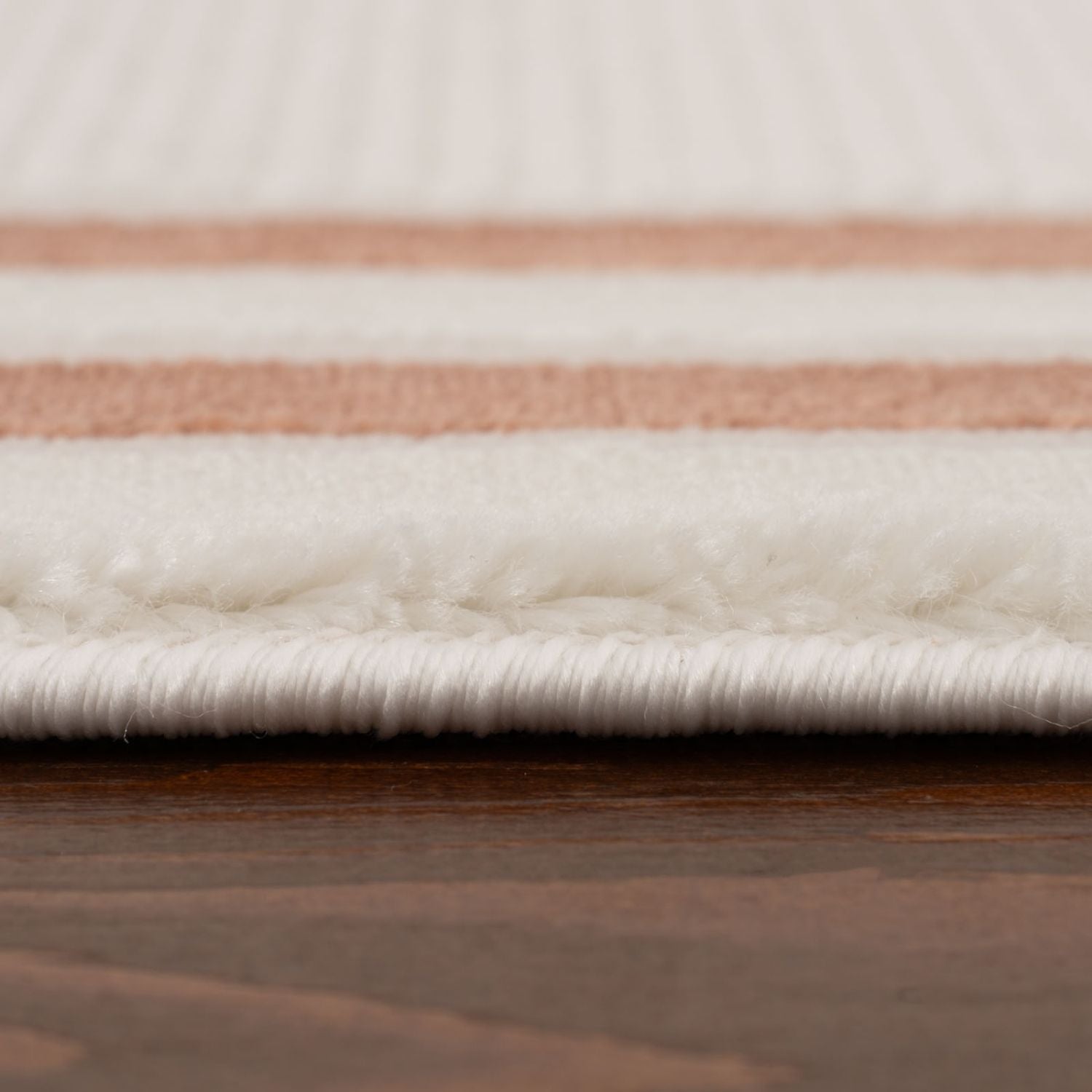 A plush white and rose gold striped cream-terra bordered rug with a soft textured pile perfect for cozy spaces
