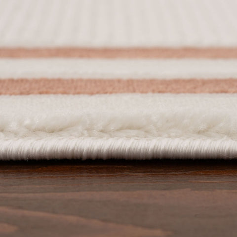A plush white and rose gold striped cream-terra bordered rug with a soft textured pile perfect for cozy spaces