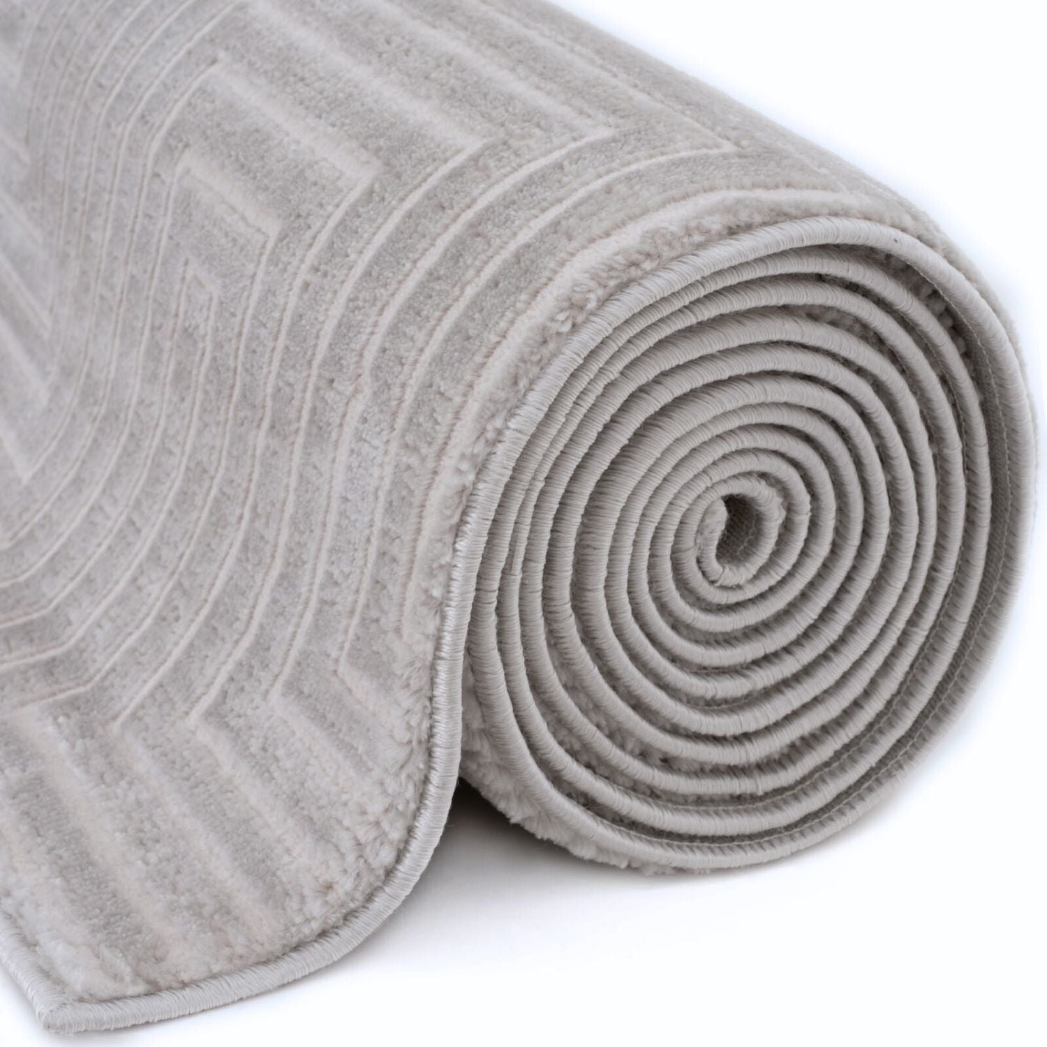 A plush light gray geometric rug with a subtle pattern rolled into a neat cylinder carmel grey cream 6050