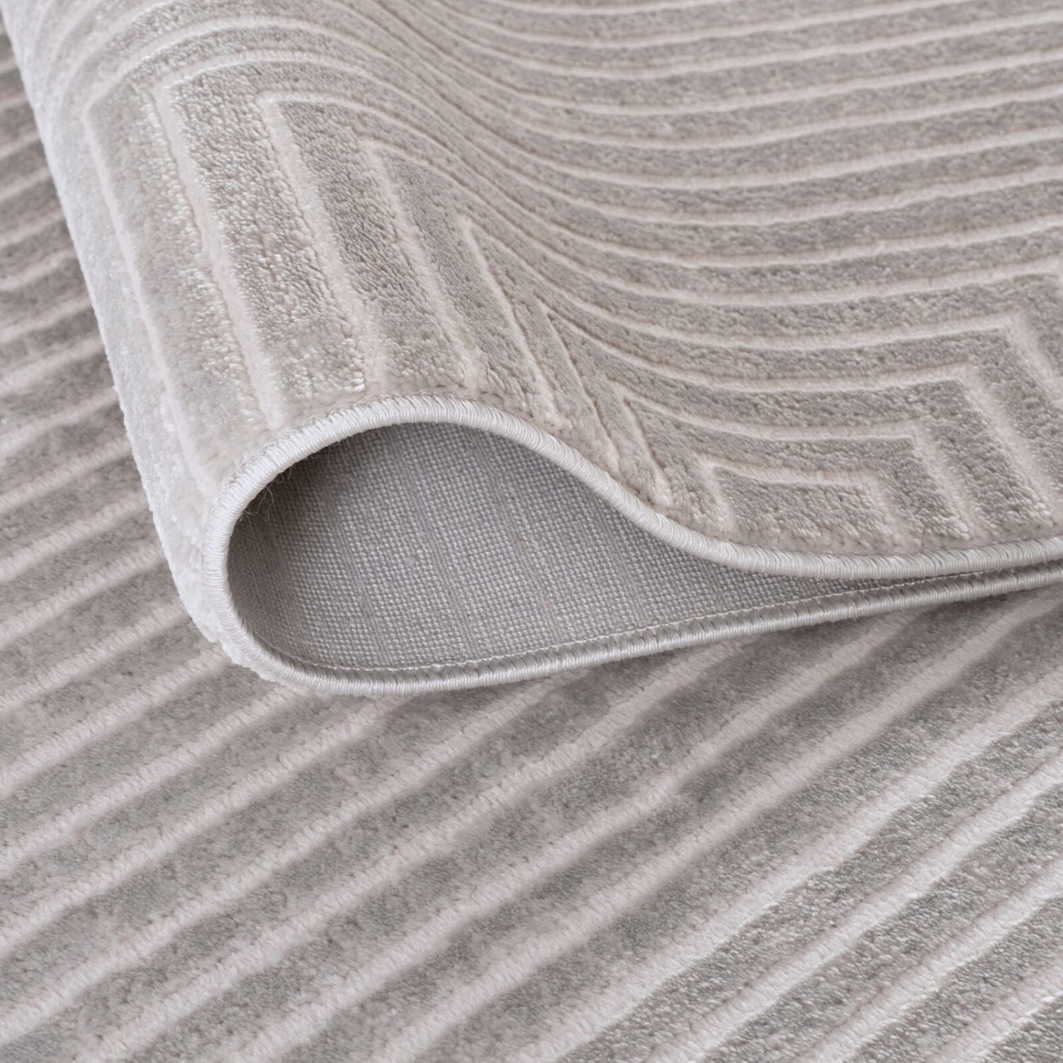 A soft gray cream geometric rug with wavy texture and plush terry cloth surface carmel grey cream 6050