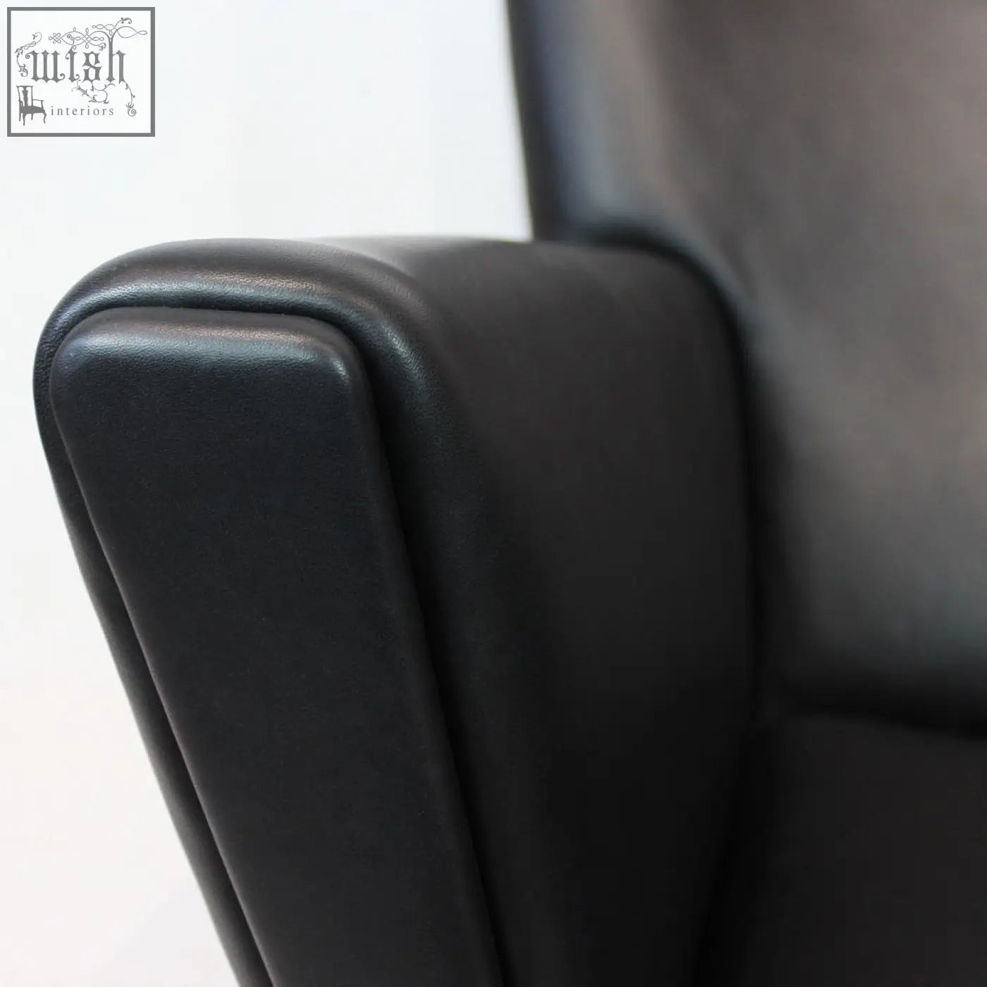 Black leather armrest of carnaby high back armchair with ottoman features smooth edges and selected high-density elastic foam