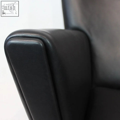 Black leather armrest of carnaby high back armchair with ottoman features smooth edges and selected high-density elastic foam