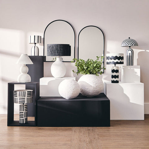 White papier mache spherical vases with matte finish on black console complement carta black and white papier mache table lamp with geometric lines