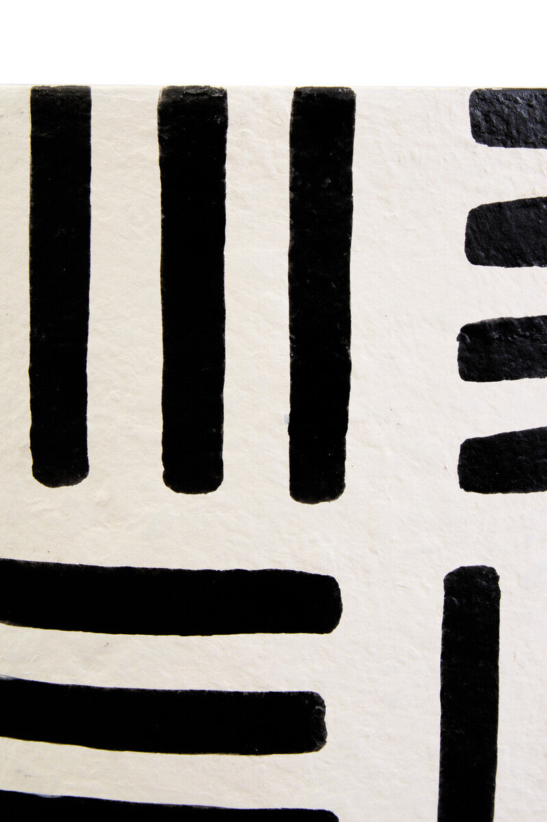 Black brushstroke lines on textured off white white papier mache surface of carta mache table lamp