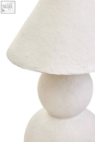 White papier mache table lamp with a white textured matte lampshade and rounded stacked base for cozy lighting