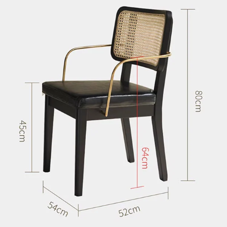 Cassie black dining chair with black leather seat and woven cane backrest framed by gold metal arms and legs