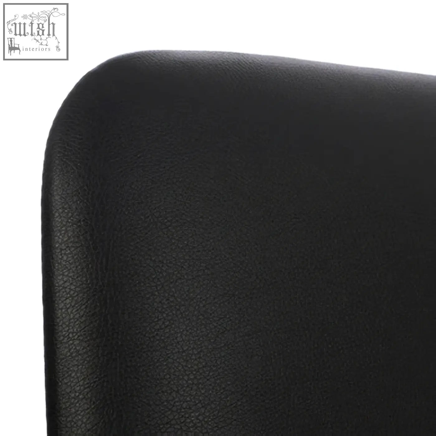 Back side of cassy black leather dining chair with subtle pebbled texture and white legs visible