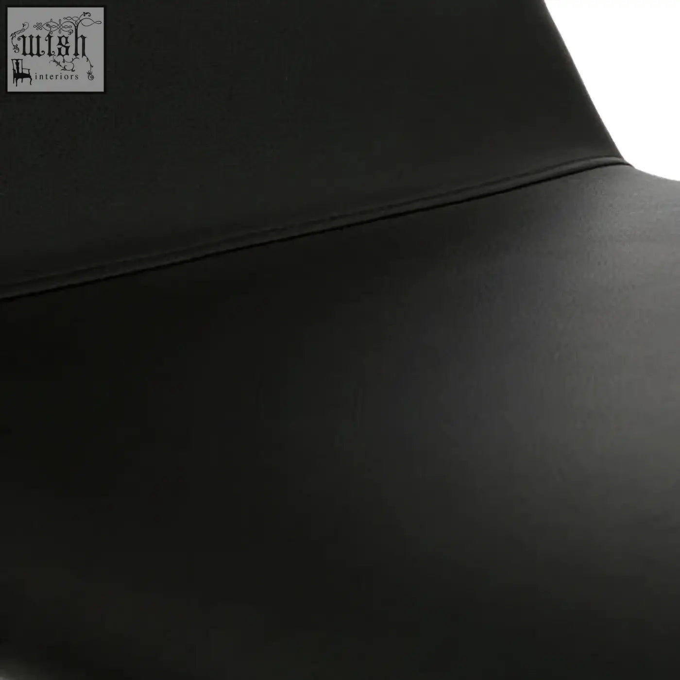 Close-up of cassy black leather dining chair seat with smooth surface and white legs visible at the edge