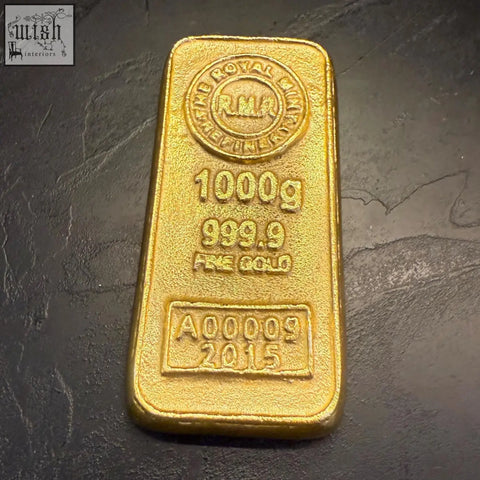 A polished 1000 gram royal mint gold bullion bar paper weight made from solid cast aluminium with engraved markings