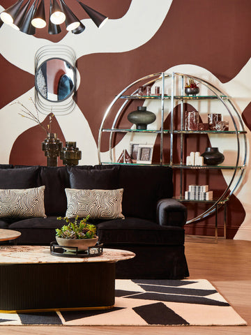 Black velvet sofa with geometric throw pillows next to a small black smoked glass vase called cayden small black smoked