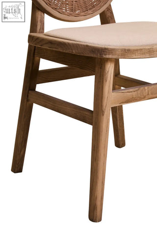 A rustic white wash elm wood dining chair with woven rattan back and beige fabric seat perfect for your dining room