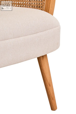 Beige upholstered cebu chair with ivory fabric, woven cane back, and elm wood legs for comfortable seating