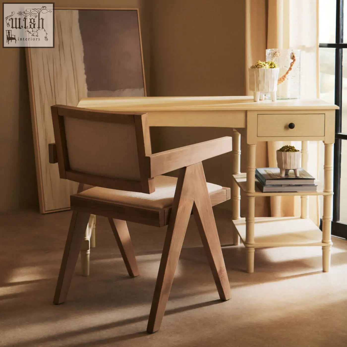 Light-colored beech wood desk with single drawer and slender legs next to a cebu ivory fabric grey wash beech wood chair