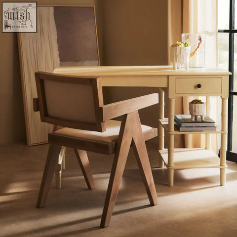 Light-colored beech wood desk with single drawer and slender legs next to a cebu ivory fabric grey wash beech wood chair