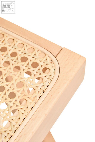 Light-colored wooden frame dining chair with cebu natural cane woven seat in an intricate circular pattern