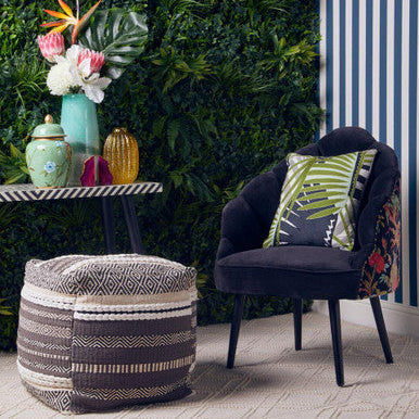 Dark navy velvet armchair with leaf cushion and floral side panels paired with cefena grey and white pouffe
