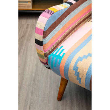 A vibrant multicolored fabric chair with bold geometric patterns and sturdy mango wood legs