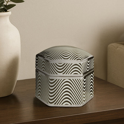 A sleek large trinket box with a bold black and white wavy pattern and metallic trim with a coordinated lid