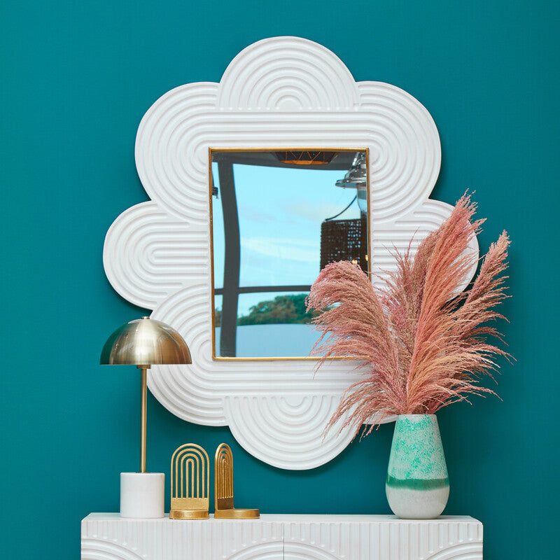 White cloud-shaped mirror with gold frame and circular ridges complements large turquoise and white ombre vase decor