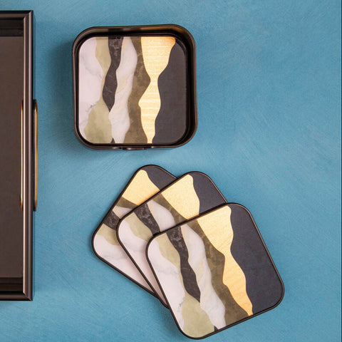 Celina set of four square coasters with abstract black white and gold wavy patterns and dark metallic border