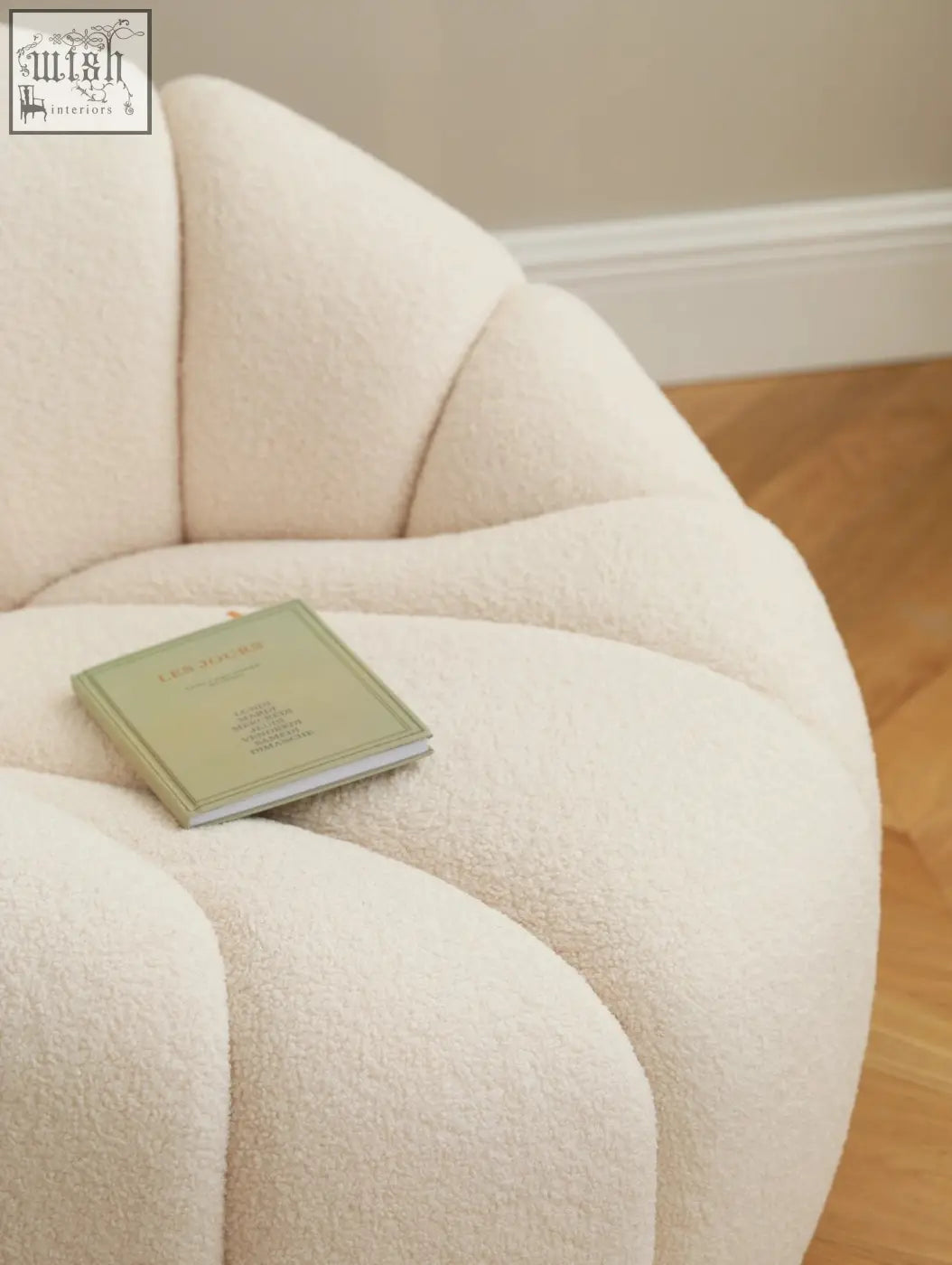 Cream-colored pumpkin round armchair with plush shell shape and soft white boucle fabric finish