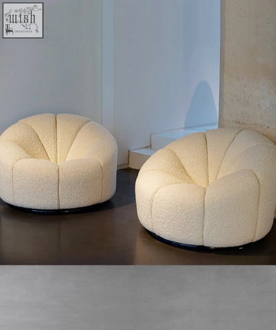 Cream-colored pumpkin round armchair with plush boucle fabric and black circular base perfect for cozy seating