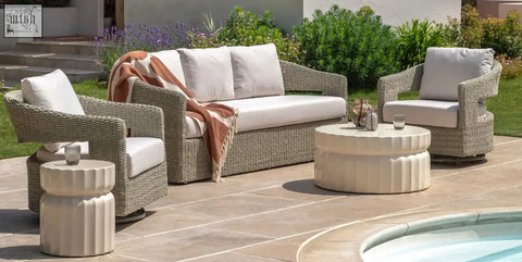 Beige wicker outdoor sofa set with white cushions and a terracotta throw near celino coffee table with cream glazed surface