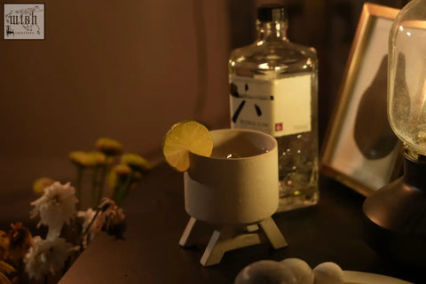 Beige ceramic chair whisky cup with minimalist tripod base garnished with a lemon slice for whisky drinkers