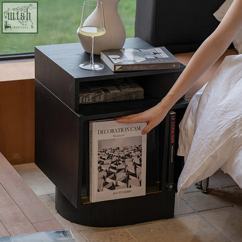 Black minimalist chatterjee bedside table with sleek curved base and open shelving for book holder storage