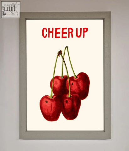 A vibrant cherries framed wall art with red cherries and bold red cheer up text in a simple frame