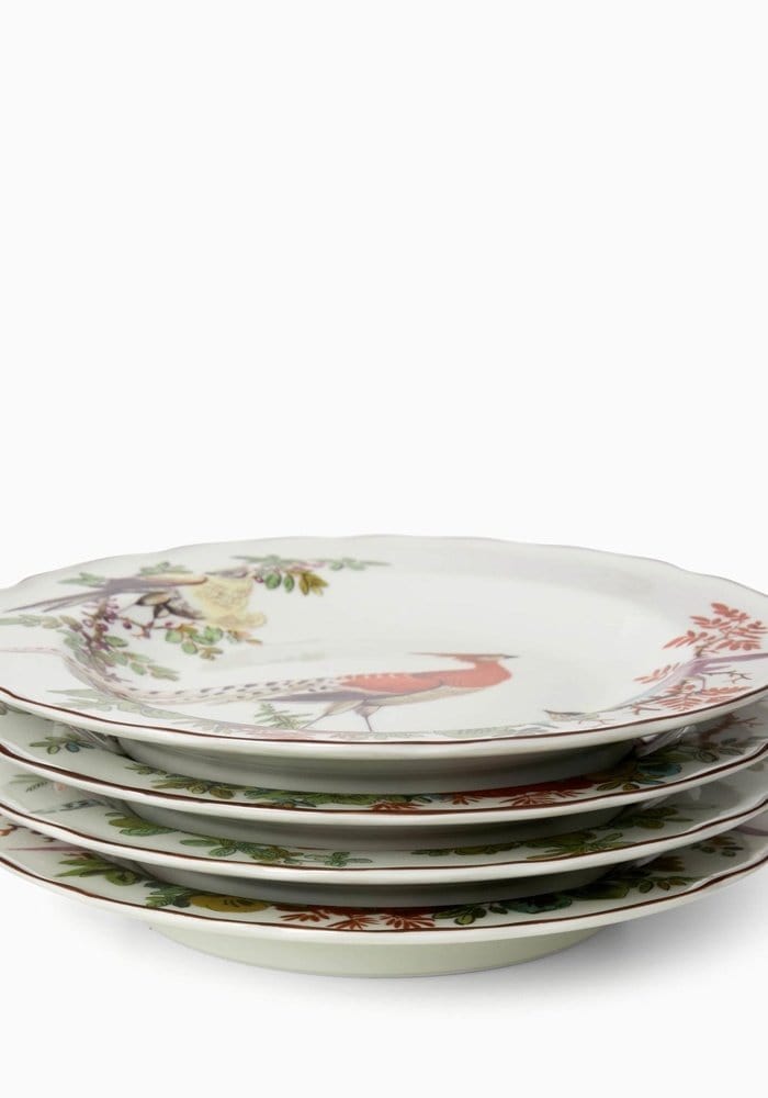Stack of four white ceramic chelsea bird side plates with hand-painted red green and brown bird and foliage designs