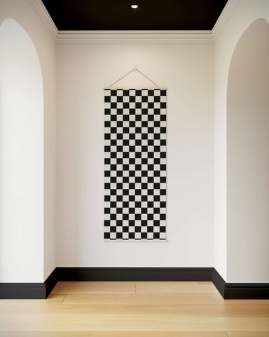 Black and white chequerboard wall tapestry with a simple triangular hanger for easy display and style