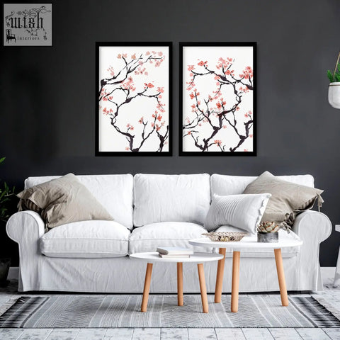 Two cherry blossom wall art prints with black branches and pink flowers in sleek black frames for home decor