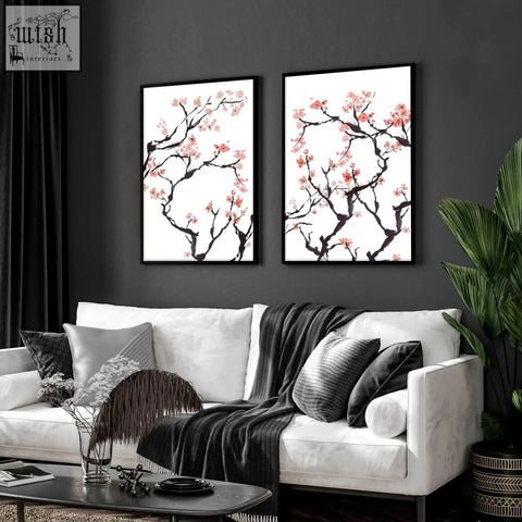 Two framed cherry blossom wall art prints with pink blossoms on dark branches in black frames on white background