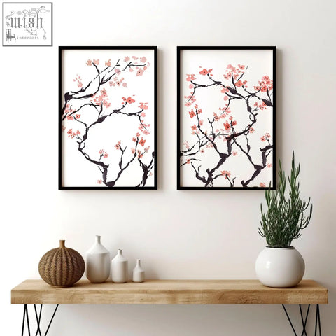 Two framed cherry blossom wall art prints with black branches and pink blossoms in sleek black frames set of 2