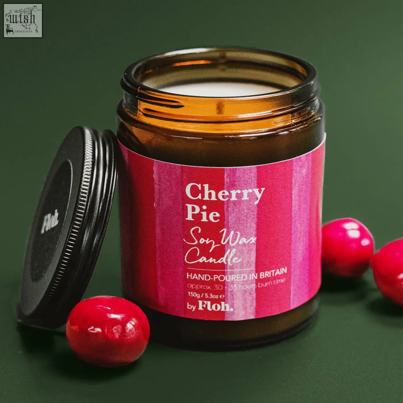 A vibrant pink-labeled cherry pie apothecary candle in amber glass by floh made with soy wax